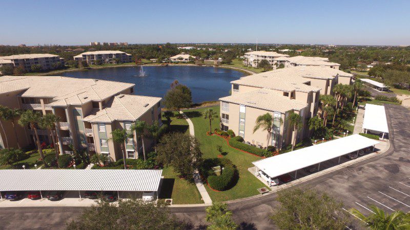 Aerial view of apartment complex with lake.